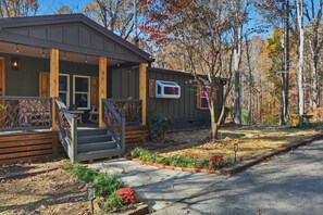 A cabin with a porch, a small deck, and a window.