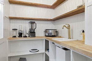 A kitchen with a wooden countertop, a sink, a coffee maker, a blender, and a toaster. - Cute Cottage, Central Location, Pet Friendly (Greer)
