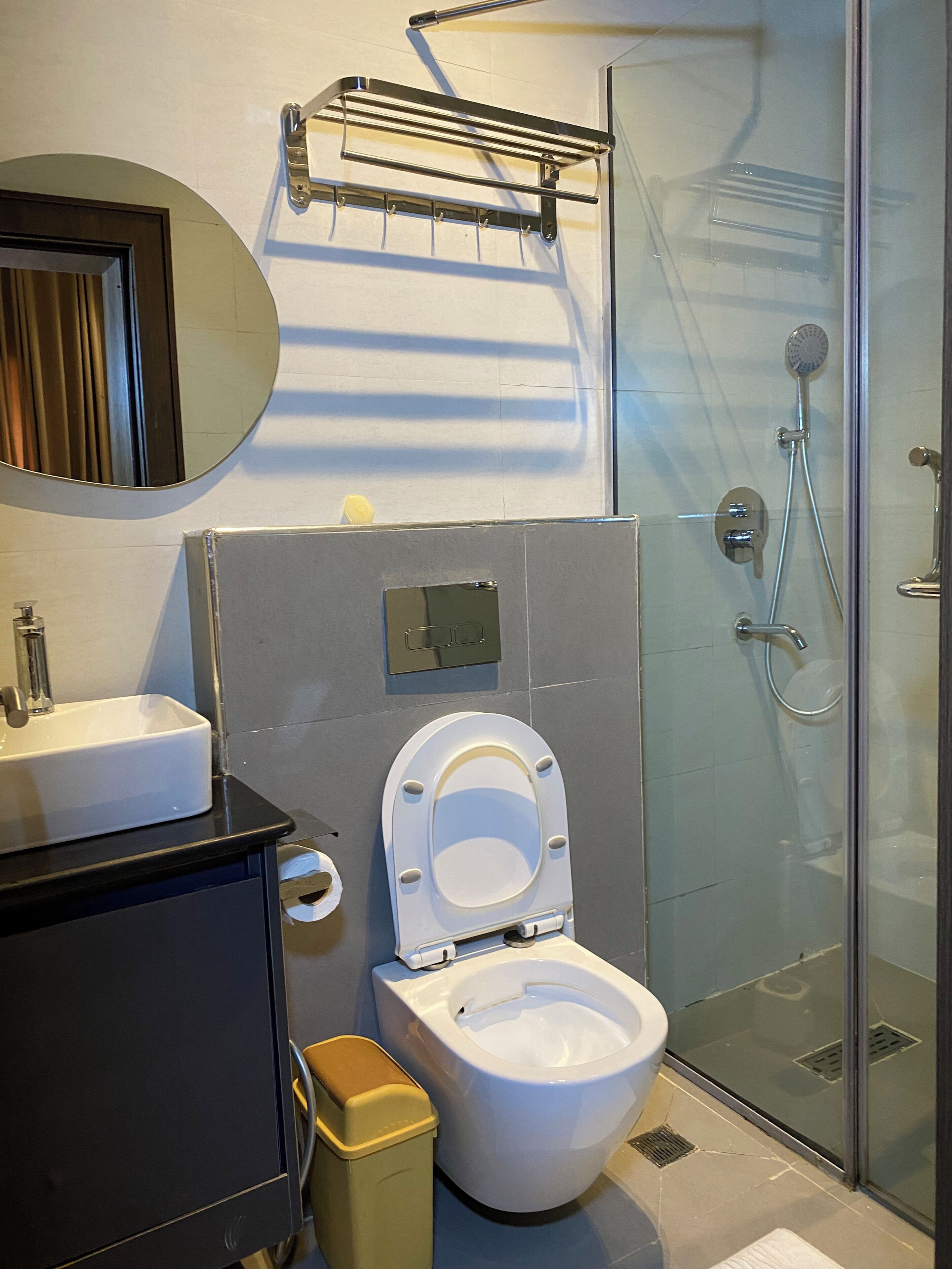 Un baño moderno con inodoro, lavamanos y ducha.