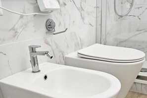 A bathroom with a white sink, a toilet, and a shower area. - Duomo at 8 min - Downtown, Qc Terme, 2 roomsDuomo at 8 min - Downtown, Qc Terme, 2 ca (Milan)