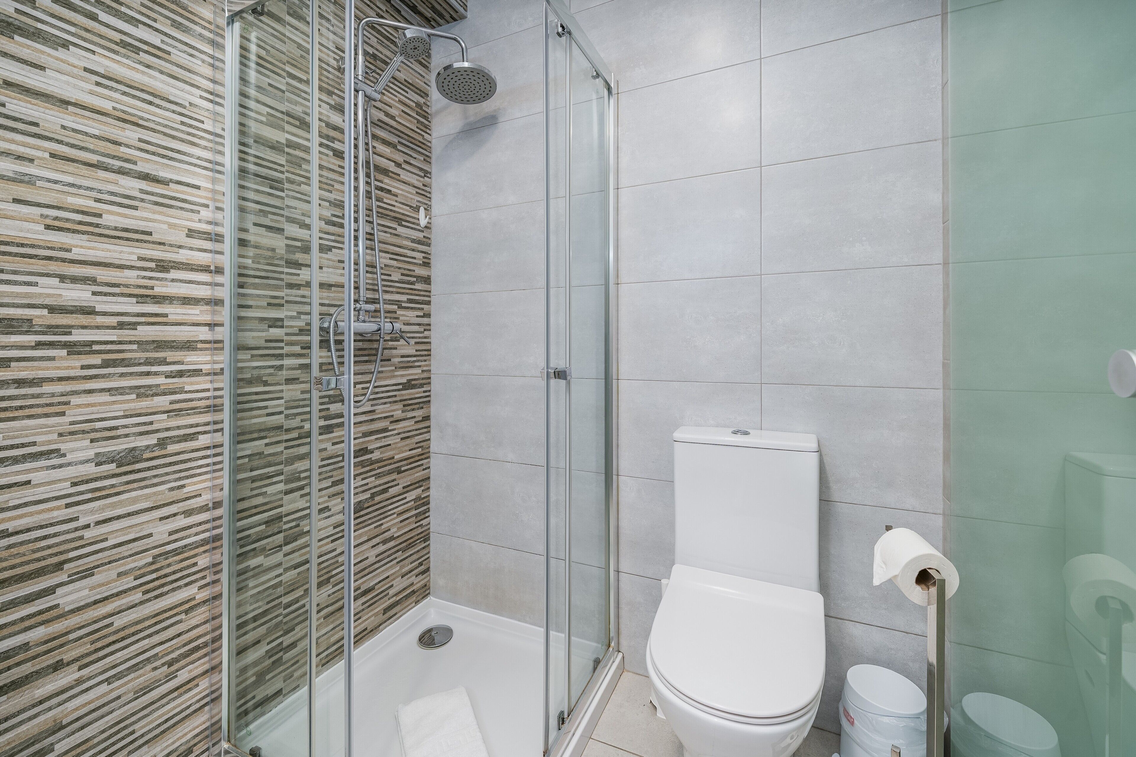 Ein modernes Badezimmer mit einer Duschkabine, einer Toilette und einem Bidet.