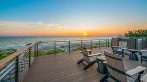 A deck with outdoor seating overlooking a sunset over the ocean. - Dream State ~ Gulf Front/Across from Beach! (Bradenton Beach)