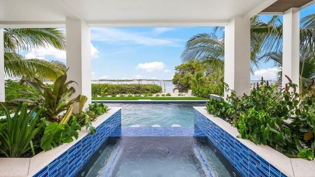Une piscine avec vue sur une plage et des palmiers.