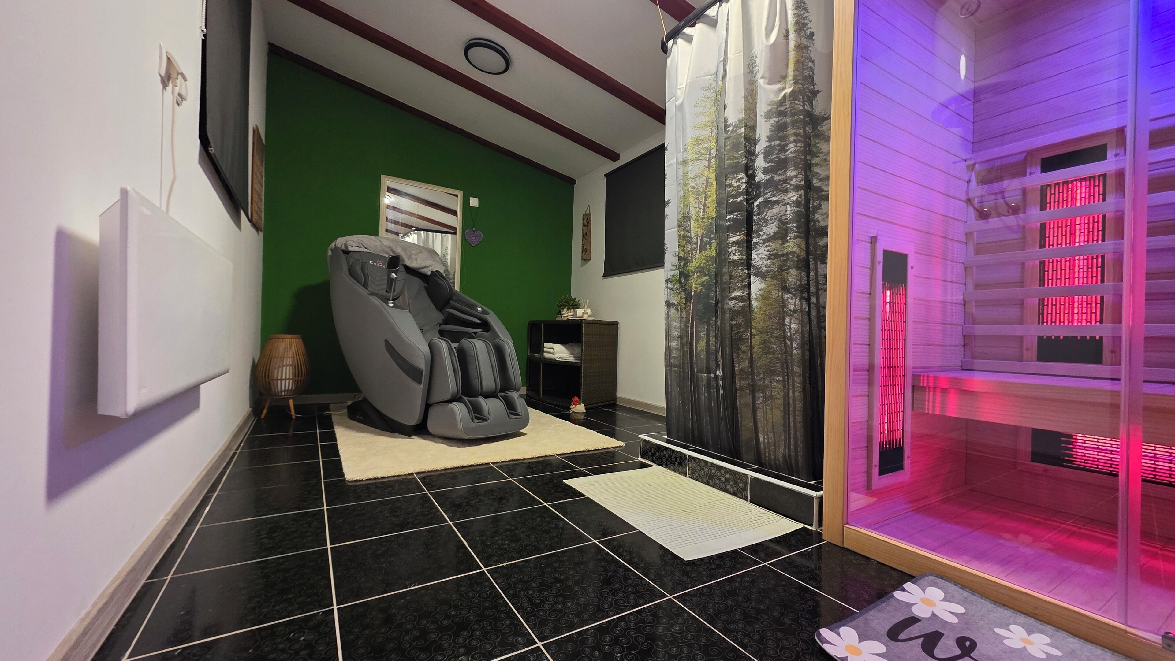 A massage chair in a room with green walls, a black tiled floor, and a glass enclosure with red lighting.