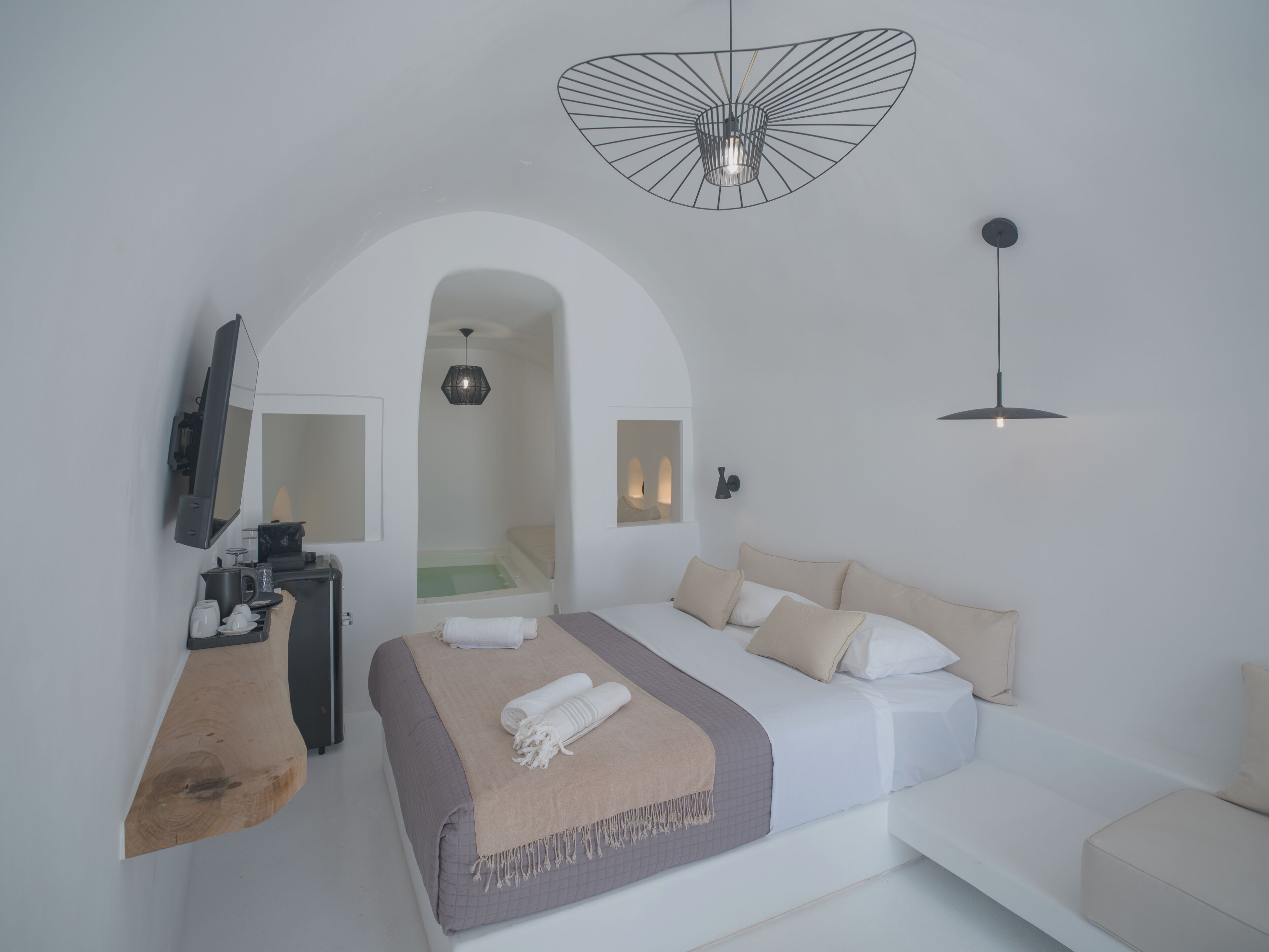 Une chambre moderne comprenant un lit, un bureau, un miroir et un espace douche.