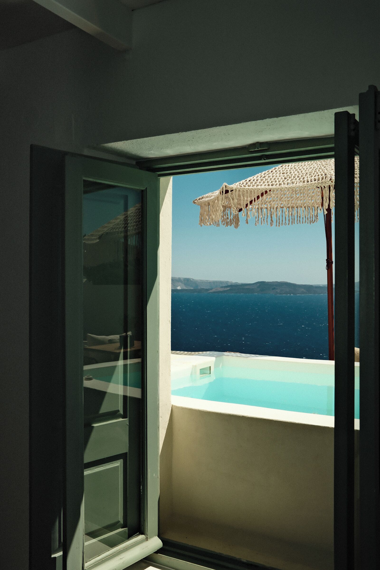 A balcony with a view of the sea and a beach umbrella.