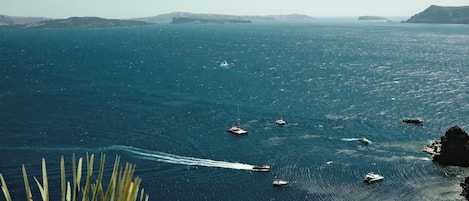 A coastal view with boats on the water and a rocky shoreline.