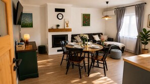 A dining area with a round table, chairs, and a fireplace. - Romantic and family getaway home with jacuzzi, hobbit sauna, terrace, and vineyard views. (Sveti Urban)