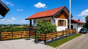 Ein zweistöckiges Haus mit roten Ziegeln, weißem Anstrich und einem Holzzaun.