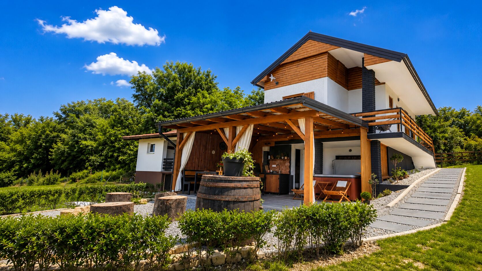 Une maison moderne à deux étages dotée d’un patio couvert, d’un espace salon extérieur et d’un chemin en pierre.