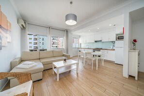 En moderne lejlighed med stue, køkken og spiseområde.