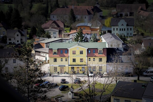 Un immeuble à plusieurs étages doté d’un toit végétalisé, entouré de maisons d’habitation.