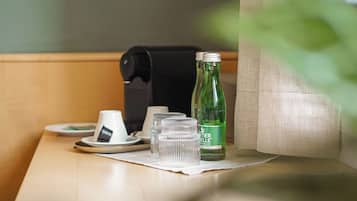 Een tafel met een koffiezetapparaat, een fles water en een kop.