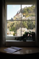 Uma janela com vista para um prédio e árvores.