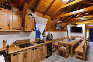 A wooden interior with a kitchen counter, dining table, and chairs.