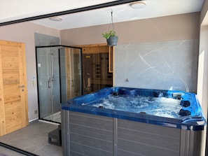 A modern bathroom with a glass shower enclosure, a wooden door, and a hot tub. - Modern villa with pool, jacuzzi, and sauna for family relaxation in Bilogora. (Maglenča)
