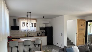 Eine moderne Küche mit Essbereich, einer Couch und einer Treppe, die zu einer anderen Ebene führt.