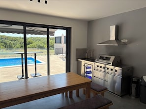 A modern kitchen with a built-in oven, a gas stove, and a stainless steel range hood.