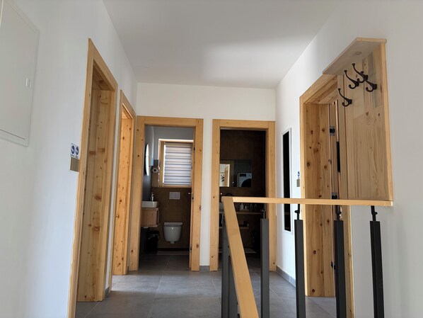 Un couloir avec des portes en bois et un escalier.