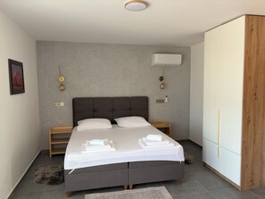 A modern bedroom with a large bed, bedside lamps, a wardrobe, and a ceiling-mounted air conditioner. - Modern villa with pool, jacuzzi, and sauna in Bilogora for relaxing getaway. (Maglenča)