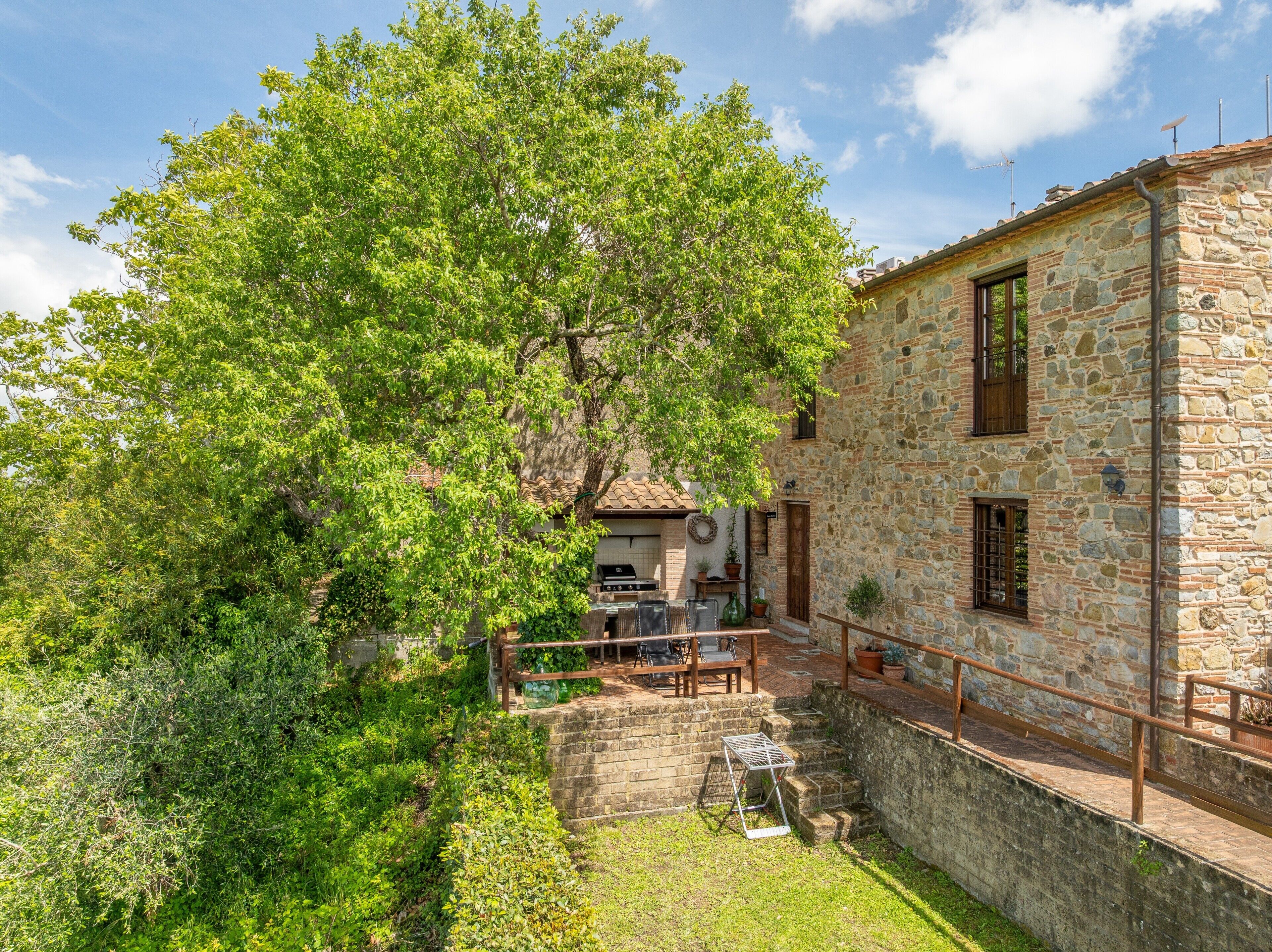 Un bâtiment en pierre doté d’un jardin, d’un espace extérieur aménagé pour s’asseoir et d’un coin barbecue.