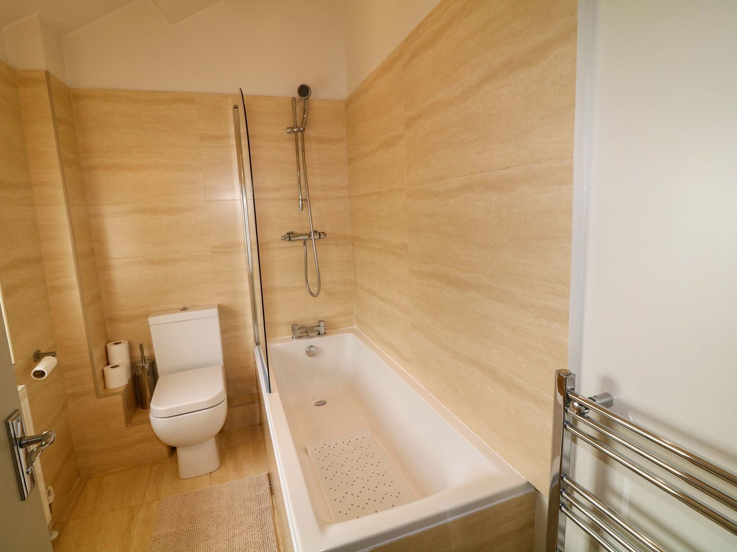 A modern bathroom with a shower, toilet, and bathtub.