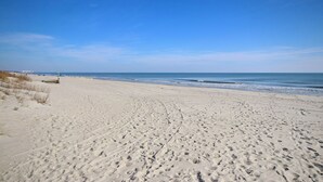 A wide sandy beach with visible footprints and a clear blue sky. - The Surf Shack-Limo Golf Cart & Linens Included in Ocean Lakes Family Campground (Myrtle Beach)