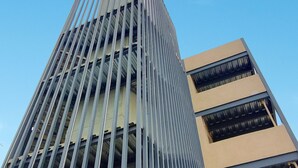 A modern high-rise building with a distinctive vertical design and large windows. - Eco Loft : Balcony with bathtub : Swimming pool and Gym : North Merida (Cholul)