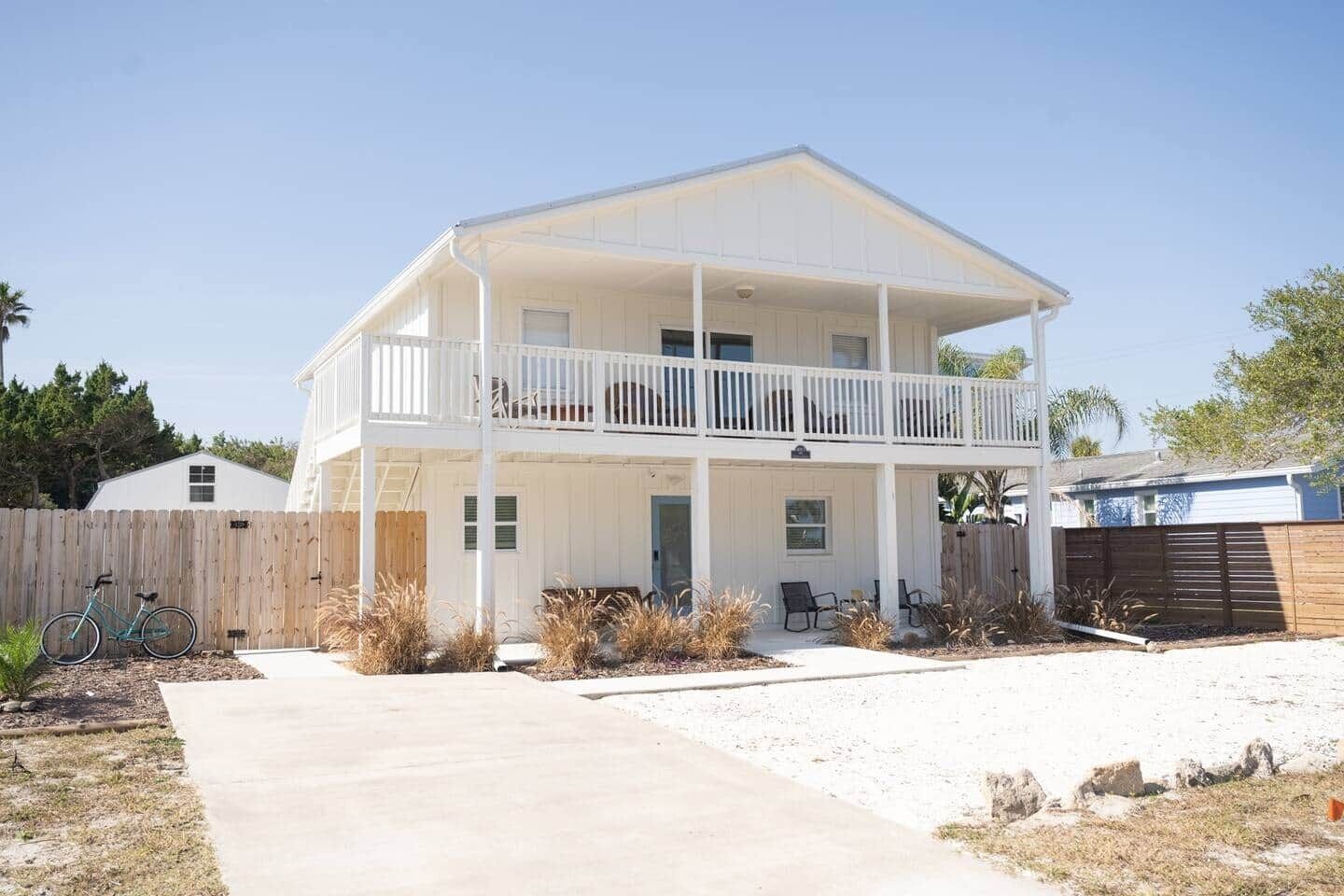 A two-story house with a balcony, a front porch, and a driveway.