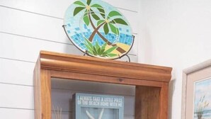 A wooden shelf with decorative items including a book, a shell, a glass jar, and a globe. - Cornerstone House (St. Augustine)