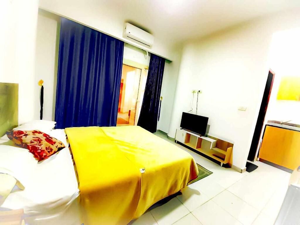 Una camera d'albergo con un letto, una televisione, una scrivania e una sedia.