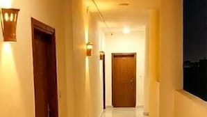 Un largo pasillo bien iluminado con pisos de baldosas y puertas a ambos lados.