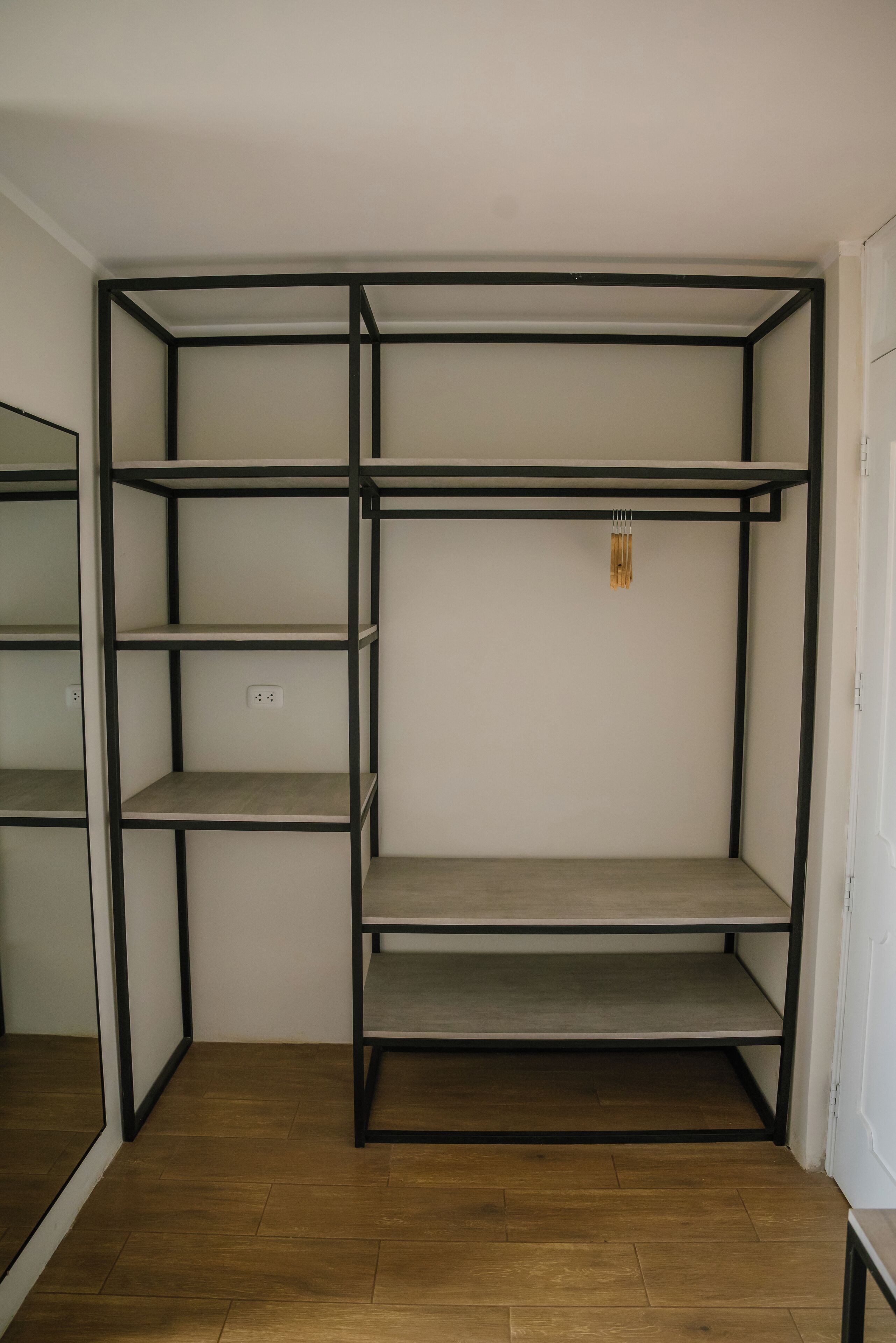 A room with a built-in shelving unit with multiple shelves and a power outlet.