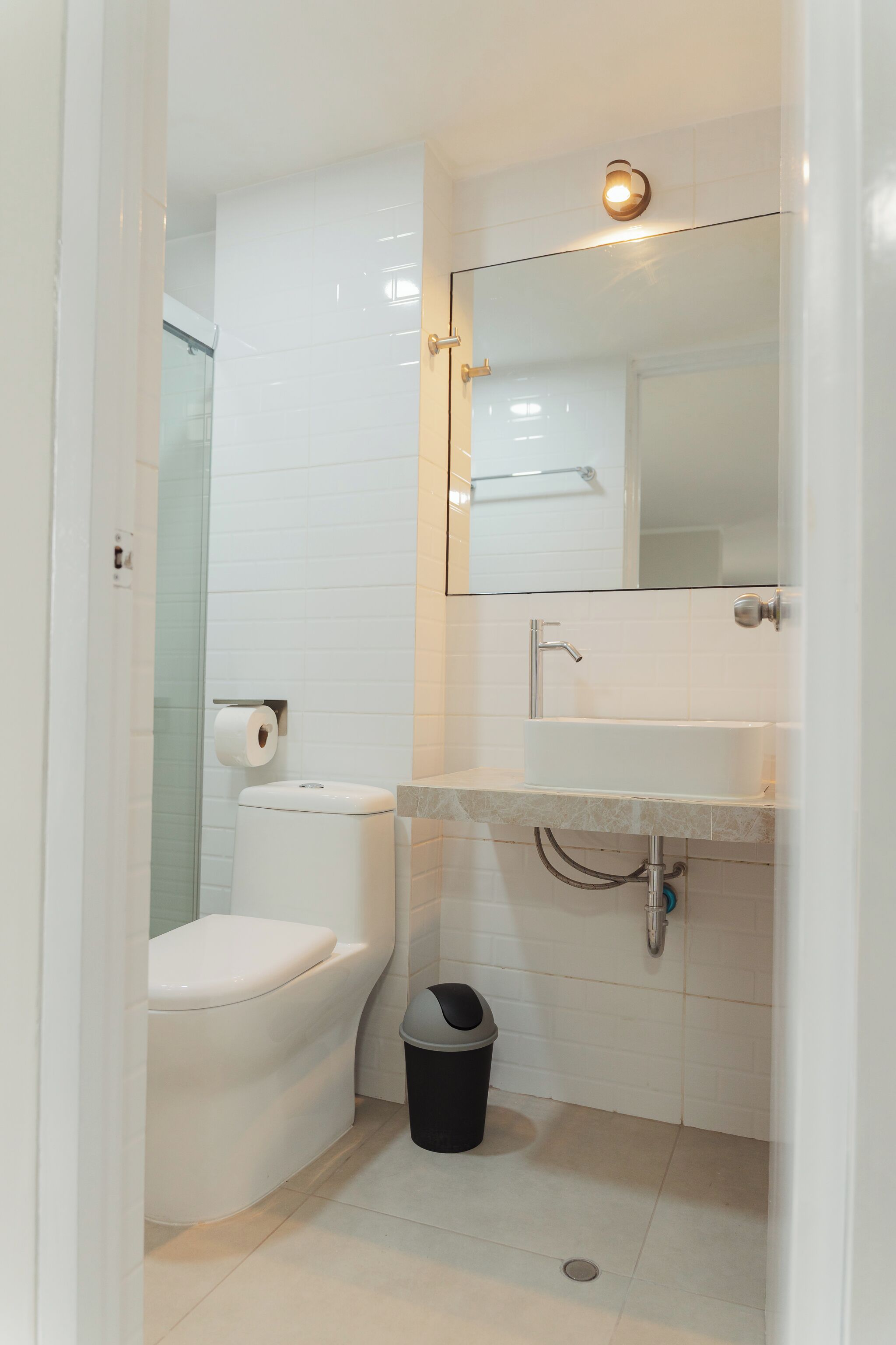 Ein modernes Badezimmer mit Toilette, Waschbecken und Spiegel.