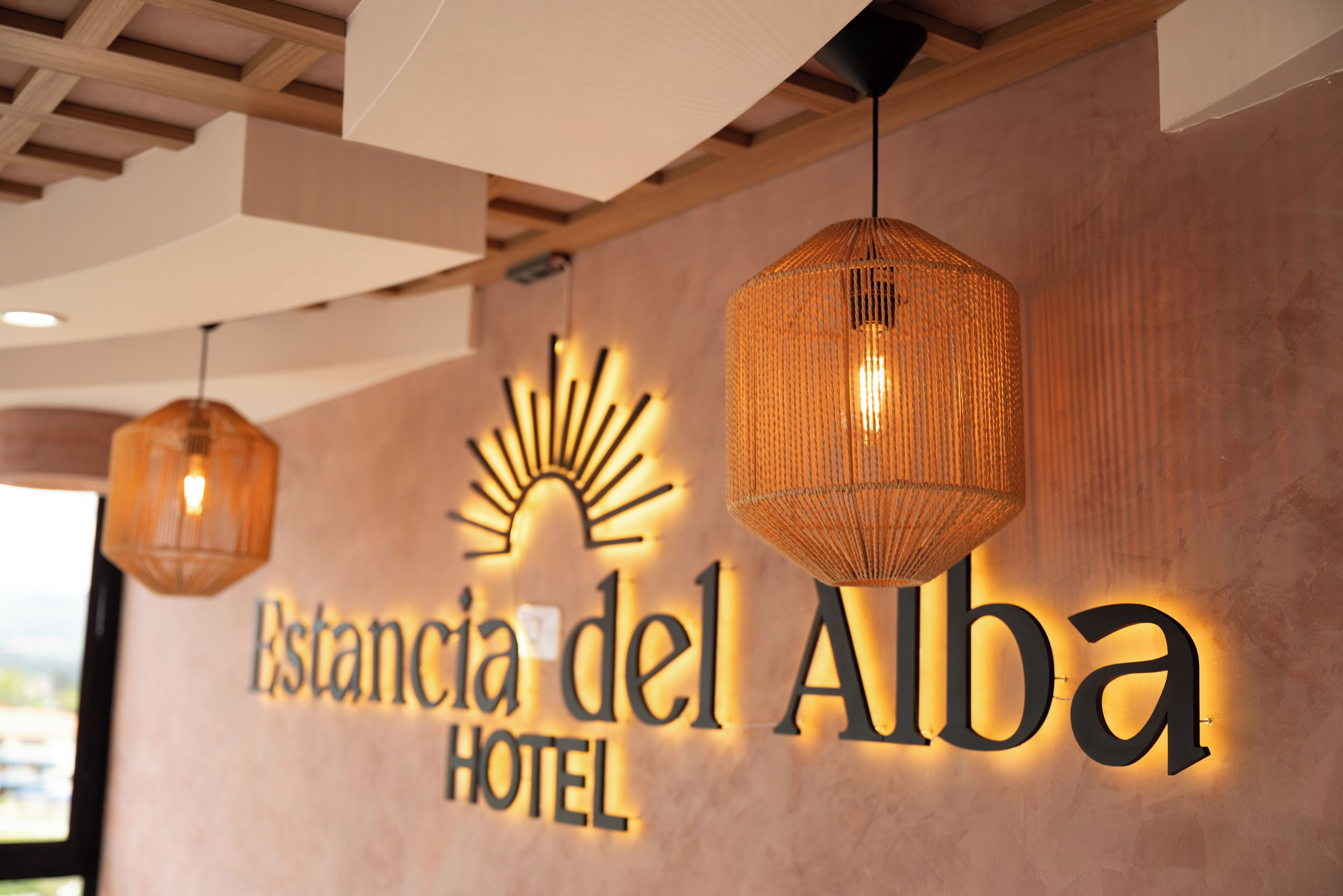 A hotel sign with the name 'Estancia del Alba Hotel'.