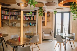 Una biblioteca moderna con estanterías, mesas redondas y asientos cómodos.