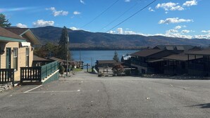 Un parking avec des bâtiments et un lac en arrière-plan.