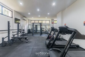 A gym with treadmills, weight machines, and a squat rack. - Apt With Balcony Steps From Barra Beach Tlr0113 (Salvador)