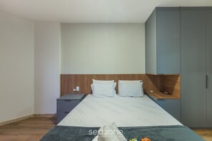 A bedroom with a bed, a nightstand, a wardrobe, and a small desk. - Apt With Balcony Steps From Barra Beach Tlr0113 (Salvador)