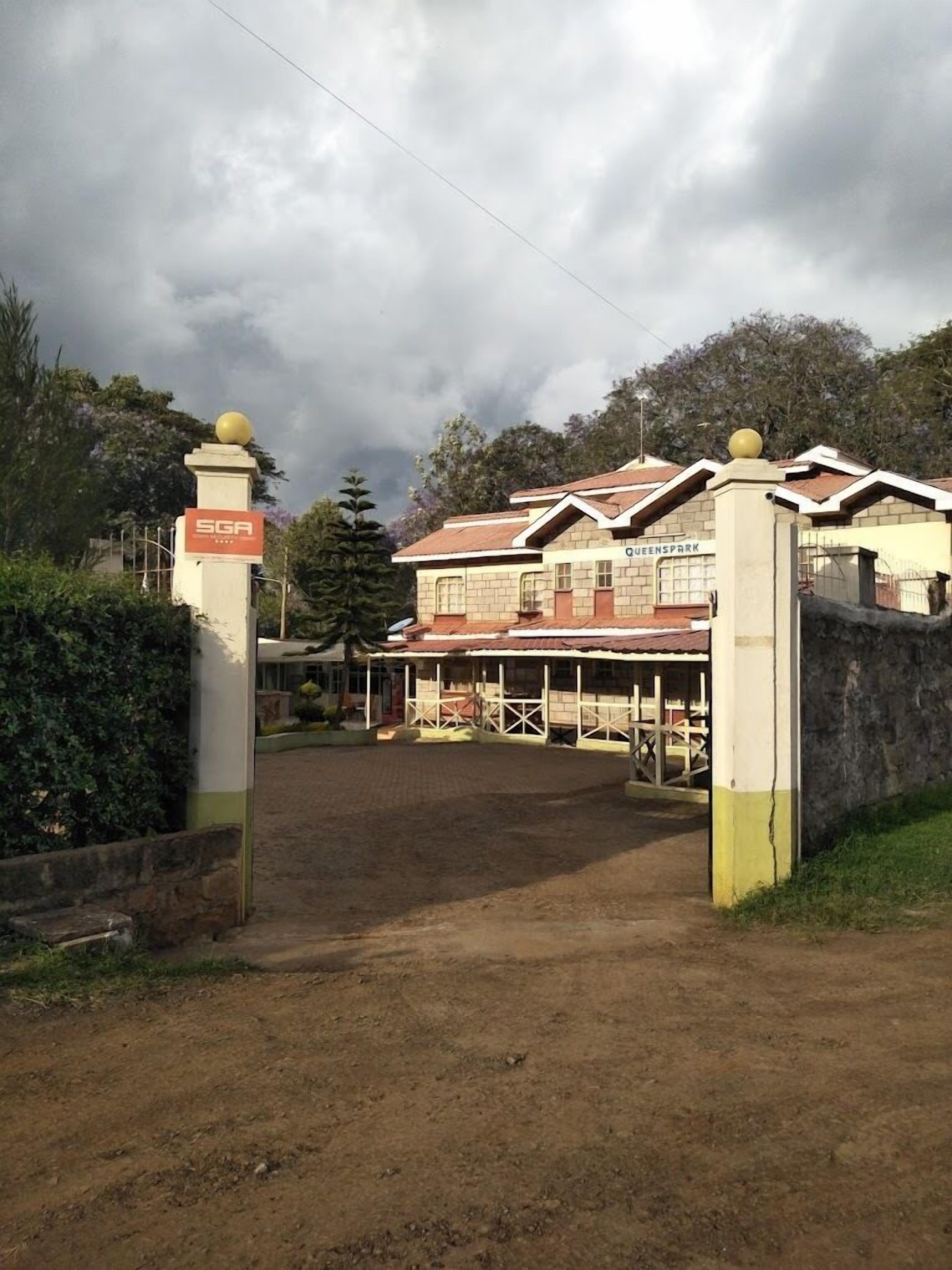 A building with a sign reading "SGA" and "QUEENS PARK".