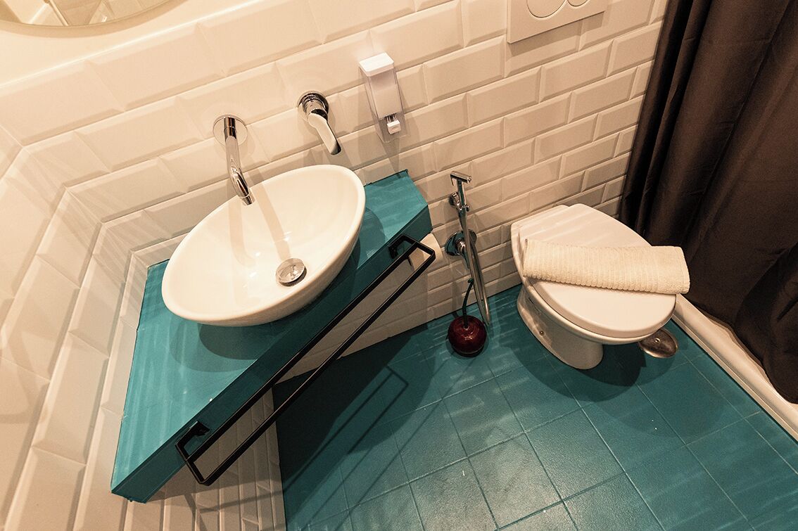 A bathroom with a white sink, a toilet, and a blue floor.