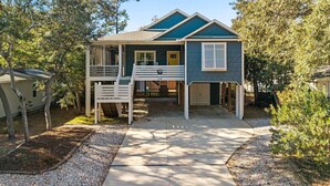 A two-story house with a covered porch, a front door, and a mailbox. - Sea La Vie𓇼Central Location𓇼Cozy𓇼Fire Pit (Oak Island)
