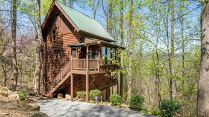 A wooden cabin with a balcony, surrounded by trees. - Dancing Dragonfly (Sevierville)