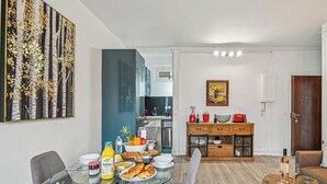 Una cocina moderna con comedor, máquina de café y frutero.