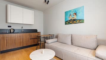 A modern living room with a sofa, a coffee table, and a painting on the wall.