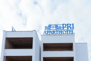 A building with a sign that reads "PRI APARTHOTEL" and features balconies with wooden railings. - PRI ApartHotel (Pristina)