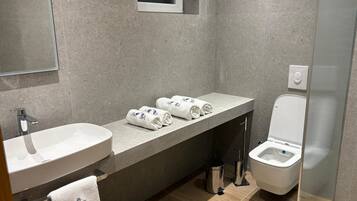 Quarto luxo | Banheiro | Chuveiro, secador de cabelo, toalhas de banho, sabonete