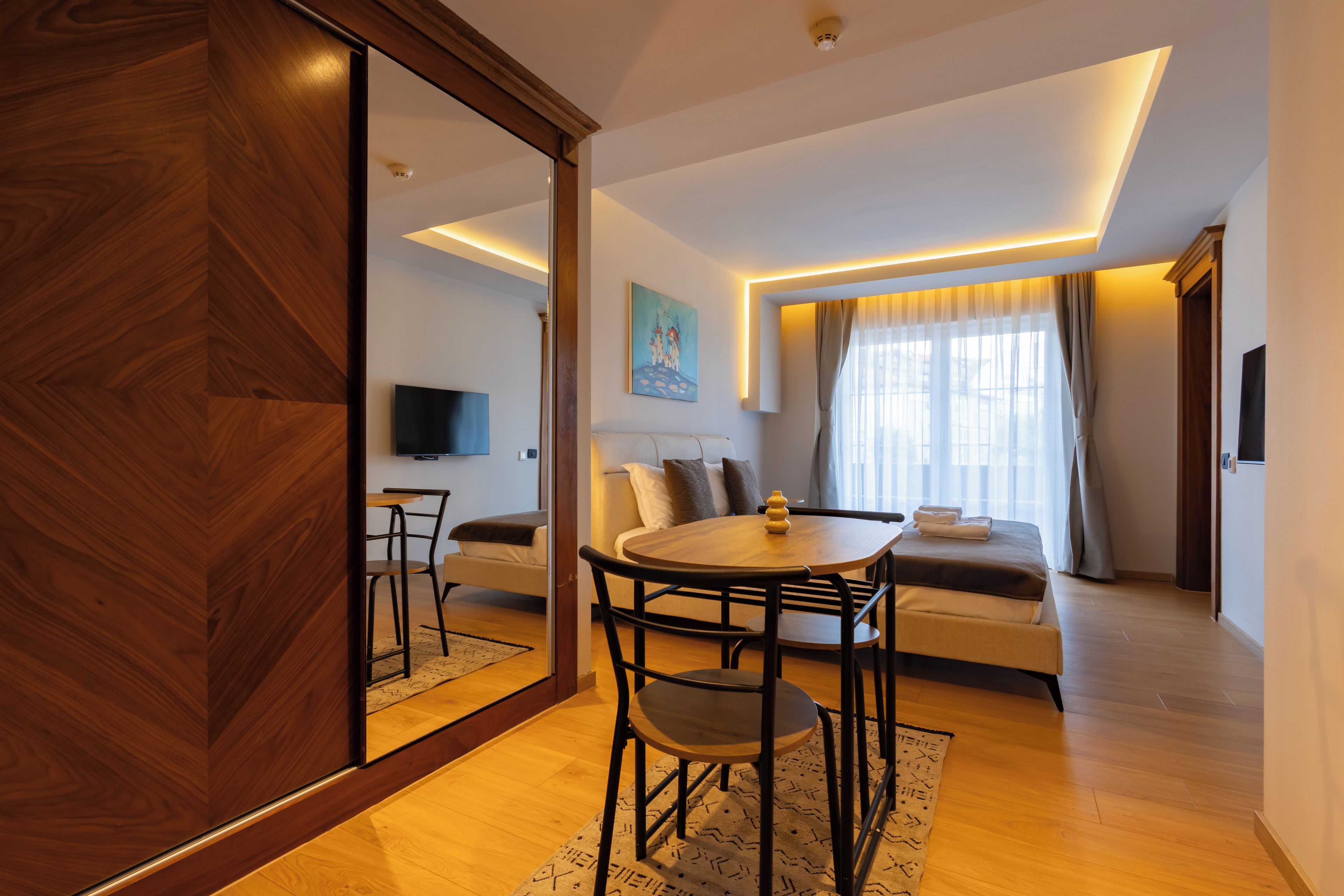 Een moderne woonkamer met een bank, een eettafel en een televisie.