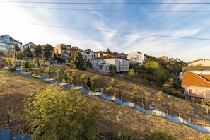 A residential area with multiple two-story houses, a staircase leading up a hill, and a clear sky. - PRI ApartHotel (Pristina)