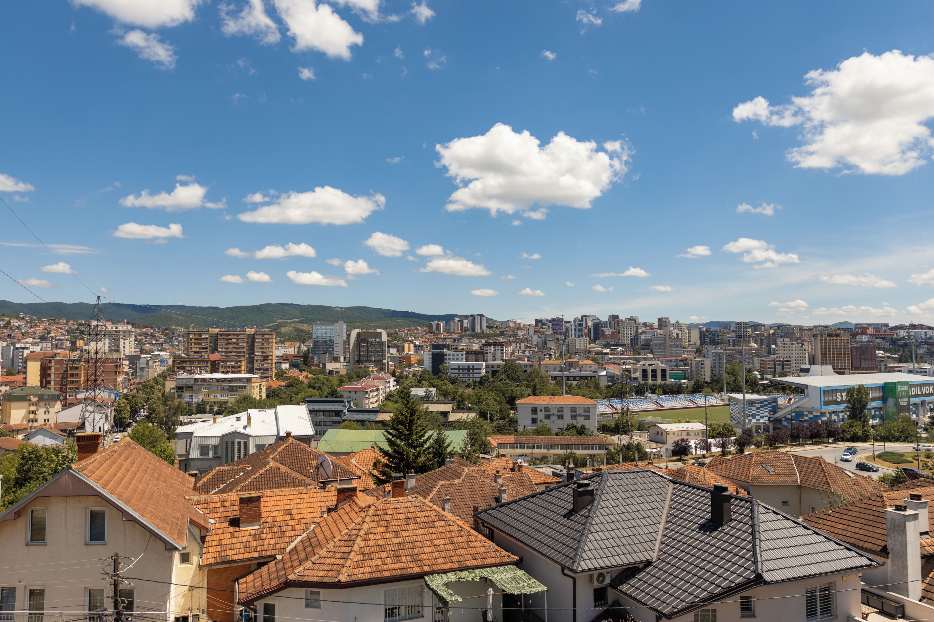 Une vue urbaine comprenant des immeubles résidentiels, un stade et un ciel dégagé.